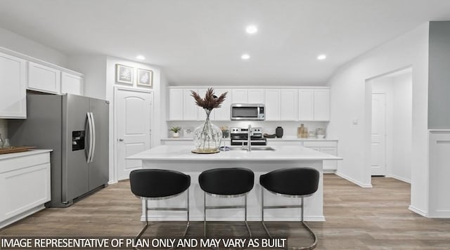 11123 Williams Reserve Dr, Conroe, TX 77303 - kitchen featuring stainless steel appliances, a kitchen breakfast bar, an island with sink, white cabinets, and recessed lighting