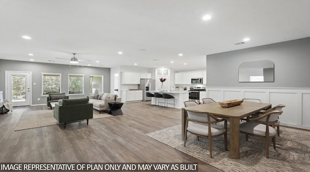 11123 Williams Reserve Dr, Conroe, TX 77303 - dining space featuring wood finished floors, a ceiling fan, recessed lighting, wainscoting, and a decorative wall