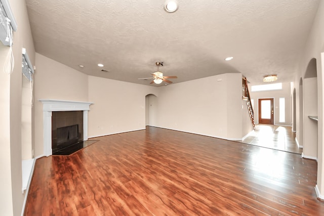 14311 Lakepointe Bend Ln, Cypress, TX 77429 - unfurnished living room with wood finished floors, arched walkways, a ceiling fan, a textured ceiling, and recessed lighting