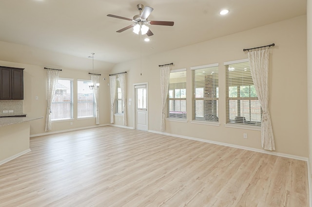19022 Summer Farm Trl, Richmond, TX 77407 - unfurnished living room with light wood-style floors, ceiling fan, recessed lighting, a chandelier, and lofted ceiling