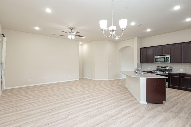 19022 Summer Farm Trl, Richmond, TX 77407 - kitchen with stainless steel appliances, arched walkways, ceiling fan, light wood-type flooring, and recessed lighting