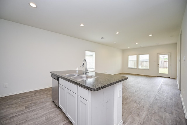 5411 Auburn Gardens Ct, Spring, TX 77373 - kitchen with stainless steel dishwasher, light wood finished floors, dark countertops, white cabinets, and recessed lighting