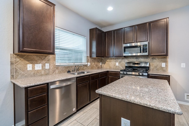 20027 Bayliss Manor Ln, Cypress, TX 77433 - kitchen featuring stainless steel appliances, dark brown cabinets, a center island, and backsplash