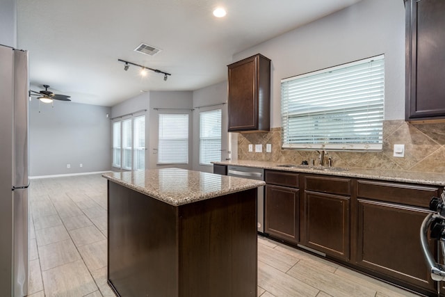 20027 Bayliss Manor Ln, Cypress, TX 77433 - kitchen with appliances with stainless steel finishes, a center island, rail lighting, dark brown cabinetry, and a ceiling fan