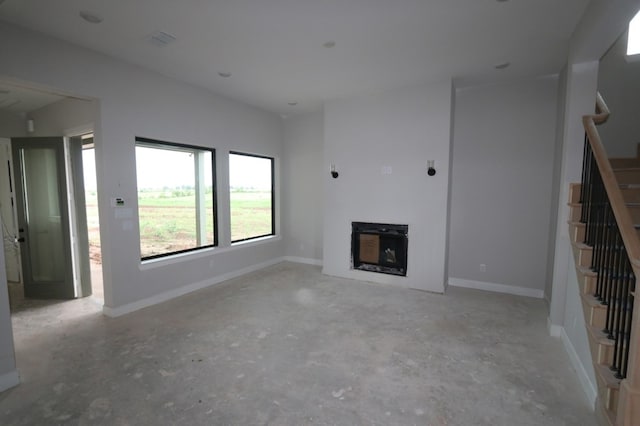 3510 Azure Ct, Richmond, TX 77406 - unfurnished living room with stairway, unfinished concrete flooring, and a fireplace