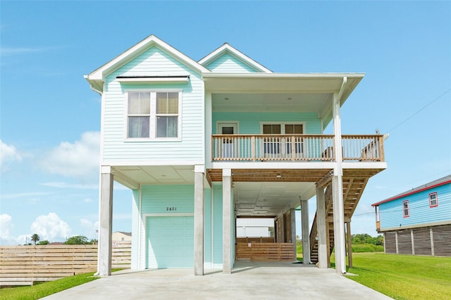 2401 103rd St, Galveston, TX 77554 - raised beach house with an attached garage, stairway, concrete driveway, a carport, and a porch