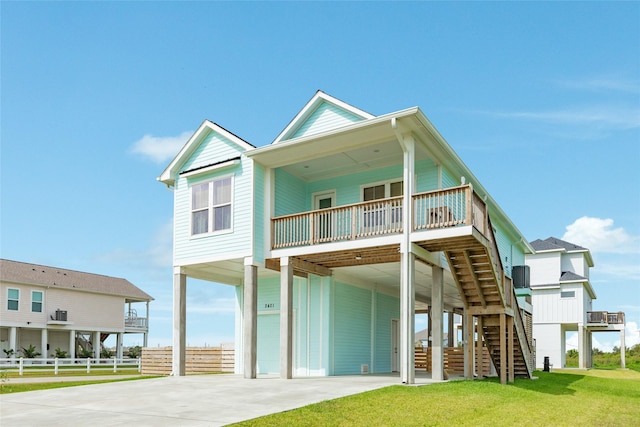 2401 103rd St, Galveston, TX 77554 - view of front of house with a carport, stairway, and concrete driveway