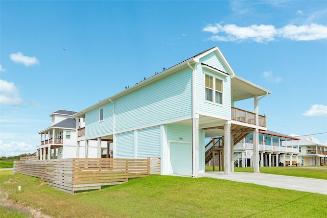 2401 103rd St, Galveston, TX 77554 - rear view of house featuring a carport, driveway, a yard, an attached garage, and stairway