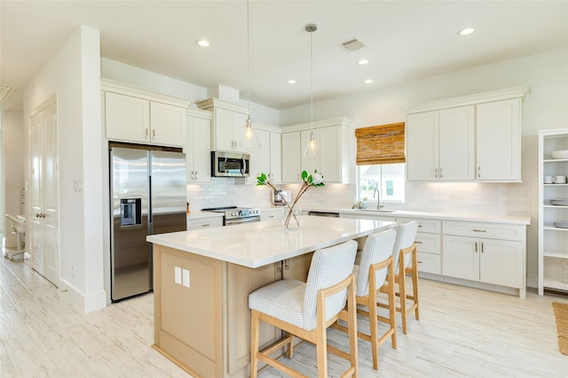 2401 103rd St, Galveston, TX 77554 - kitchen with appliances with stainless steel finishes, a kitchen island, decorative backsplash, light countertops, and recessed lighting