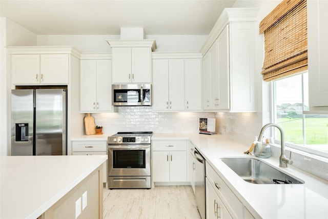 2401 103rd St, Galveston, TX 77554 - kitchen featuring appliances with stainless steel finishes, light countertops, and white cabinets
