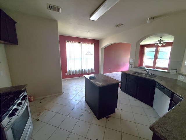 2714 Glenfield Manor Ln, Houston, TX 77014 - kitchen featuring dishwashing machine, stainless steel range with gas cooktop, arched walkways, a ceiling fan, and a center island