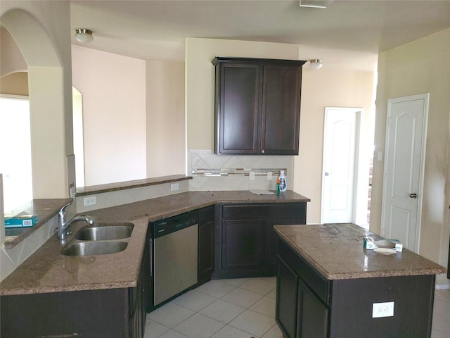 2714 Glenfield Manor Ln, Houston, TX 77014 - kitchen with dishwasher, light tile patterned floors, arched walkways, a kitchen island, and dark stone countertops