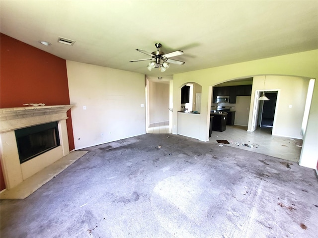 2714 Glenfield Manor Ln, Houston, TX 77014 - unfurnished living room featuring a fireplace, arched walkways, and ceiling fan