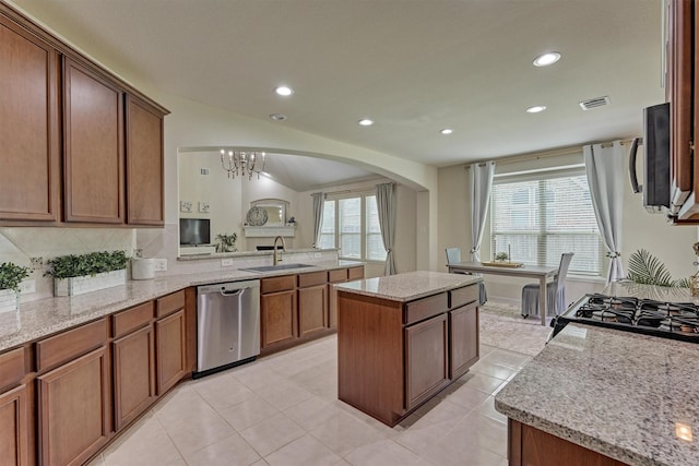 135 Forest Heights Way, Montgomery, TX 77316 - kitchen with appliances with stainless steel finishes, arched walkways, a center island, light stone countertops, and recessed lighting