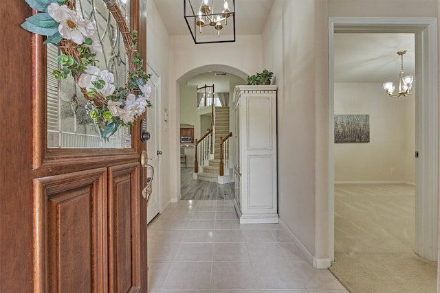 135 Forest Heights Way, Montgomery, TX 77316 - entrance foyer with a chandelier, arched walkways, light tile patterned flooring, and stairs