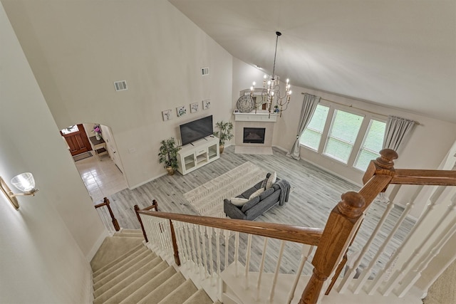 135 Forest Heights Way, Montgomery, TX 77316 - living room with a tiled fireplace, arched walkways, stairs, a chandelier, and high vaulted ceiling