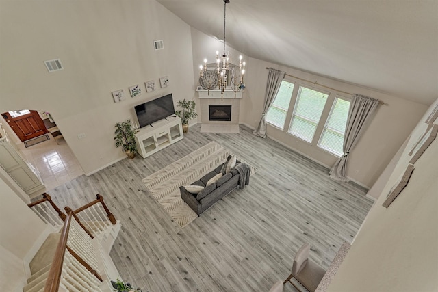 135 Forest Heights Way, Montgomery, TX 77316 - living area with a fireplace, a chandelier, high vaulted ceiling, and light wood-type flooring