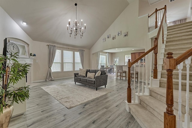 135 Forest Heights Way, Montgomery, TX 77316 - living room featuring arched walkways, stairway, plenty of natural light, light wood-style floors, and high vaulted ceiling