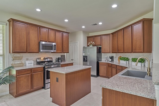 135 Forest Heights Way, Montgomery, TX 77316 - kitchen featuring appliances with stainless steel finishes, decorative backsplash, light stone countertops, a center island, and recessed lighting