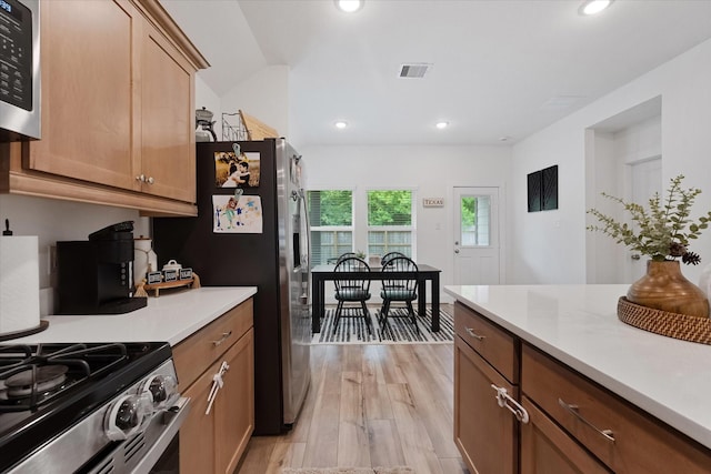 21635 Alberta Forest Cir, Magnolia, TX 77355 - kitchen with stainless steel appliances, light countertops, light wood finished floors, recessed lighting, and brown cabinetry