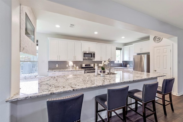 18415 Pin Oak Bend Dr, Cypress, TX 77433 - kitchen with stainless steel appliances, white cabinets, dark wood-style flooring, tasteful backsplash, and recessed lighting