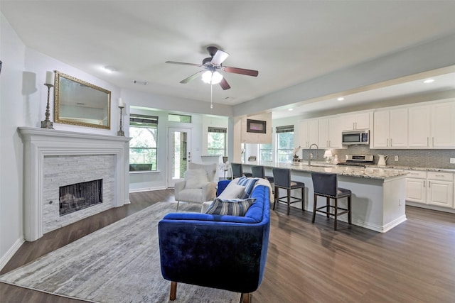 18415 Pin Oak Bend Dr, Cypress, TX 77433 - living area with dark wood-style flooring, a ceiling fan, healthy amount of natural light, a stone fireplace, and recessed lighting