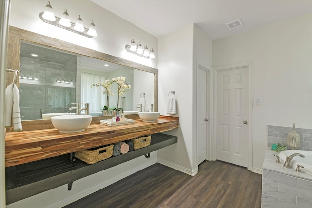 18415 Pin Oak Bend Dr, Cypress, TX 77433 - bathroom with double vanity, a garden tub, a stall shower, and wood finished floors