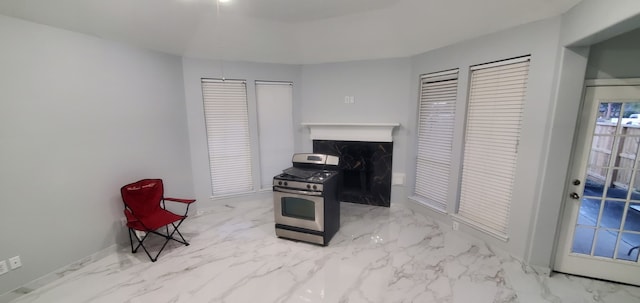 71 N Forrest Ave, La Porte, TX 77571 - kitchen with stainless steel range with gas cooktop, marble look tile flooring, and a fireplace