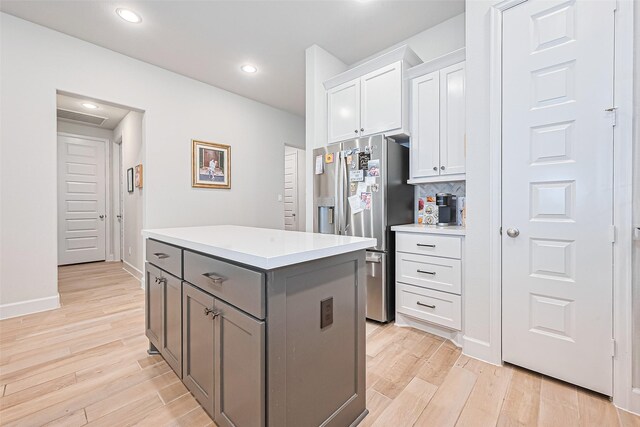 7522 Zion Grove Ct, Katy, TX 77493 - kitchen with stainless steel refrigerator with ice dispenser, a kitchen island, light wood finished floors, white cabinetry, and gray cabinetry