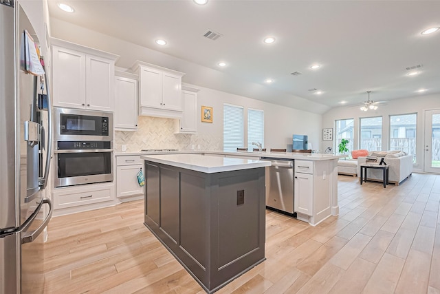 7522 Zion Grove Ct, Katy, TX 77493 - kitchen featuring appliances with stainless steel finishes, light wood-type flooring, a peninsula, open floor plan, and recessed lighting