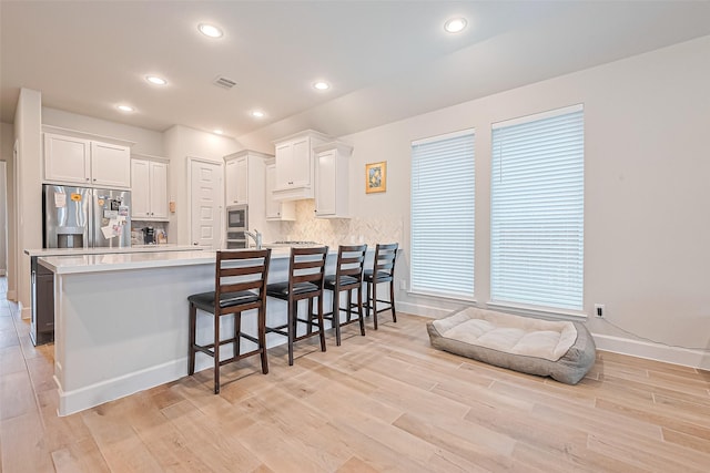 7522 Zion Grove Ct, Katy, TX 77493 - kitchen with stainless steel fridge, a peninsula, white cabinets, light countertops, and recessed lighting