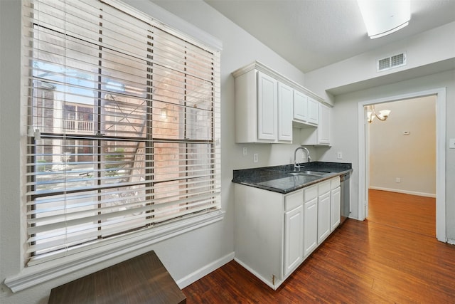 2255 Braeswood Park Dr Unit 181, Houston, TX 77030 - kitchen with white cabinets, dark wood-style flooring, a chandelier, and healthy amount of natural light
