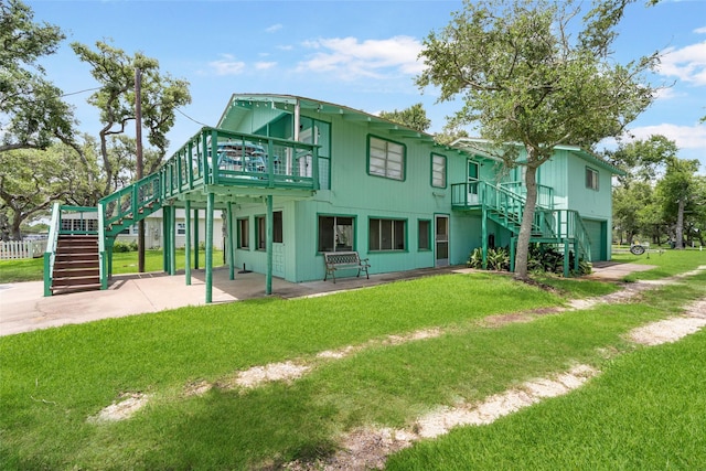 1040 County Road 206, Sargent, TX 77414 - rear view of property featuring stairs, a yard, a garage, and a patio area