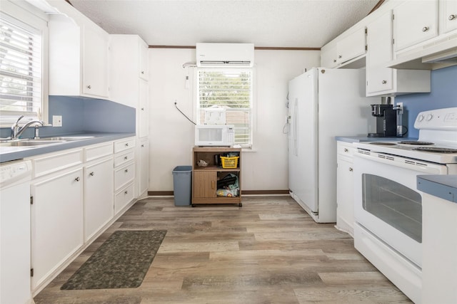 1040 County Road 206, Sargent, TX 77414 - kitchen featuring white appliances, under cabinet range hood, a wall mounted air conditioner, white cabinetry, and light wood-style floors