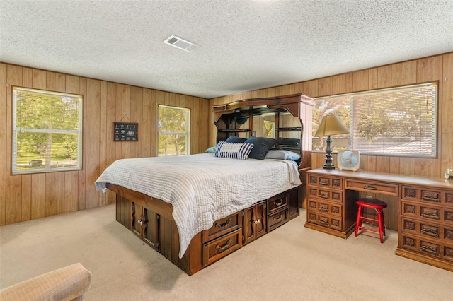 1040 County Road 206, Sargent, TX 77414 - carpeted bedroom featuring wood walls and a textured ceiling