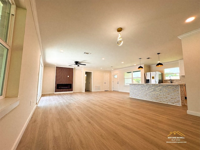 2630 34th St, Port Arthur, TX 77640 - unfurnished living room featuring ornamental molding, a ceiling fan, light wood finished floors, recessed lighting, and a fireplace