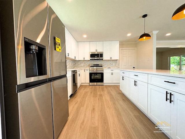 2630 34th St, Port Arthur, TX 77640 - kitchen with appliances with stainless steel finishes, light wood-style floors, light countertops, white cabinetry, and tasteful backsplash