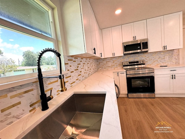 2630 34th St, Port Arthur, TX 77640 - kitchen featuring appliances with stainless steel finishes, backsplash, white cabinets, and recessed lighting