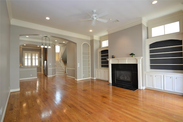 109 Dennis St, Houston, TX 77006 - unfurnished living room featuring ceiling fan, built in features, arched walkways, ornamental molding, and stairs