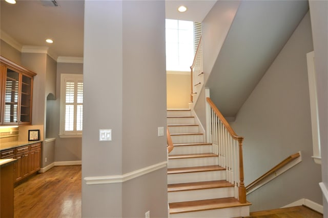 109 Dennis St, Houston, TX 77006 - stairway featuring recessed lighting, wood finished floors, and crown molding