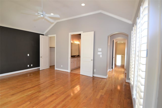 109 Dennis St, Houston, TX 77006 - unfurnished bedroom featuring arched walkways, lofted ceiling, light wood-style floors, ensuite bathroom, and a walk in closet