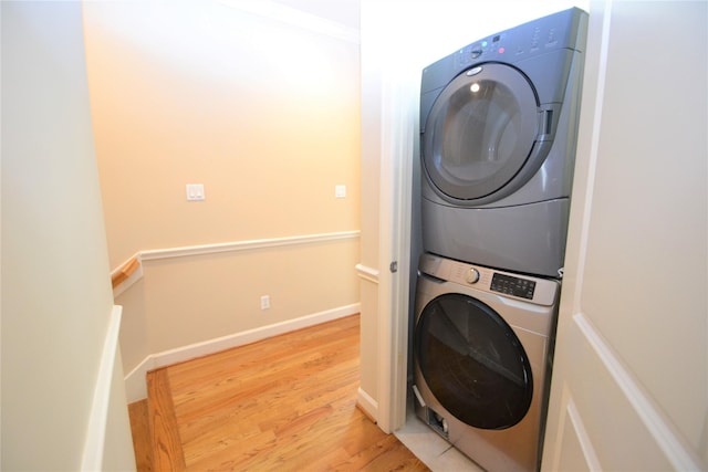 109 Dennis St, Houston, TX 77006 - washroom featuring stacked washer / drying machine and light wood-style floors