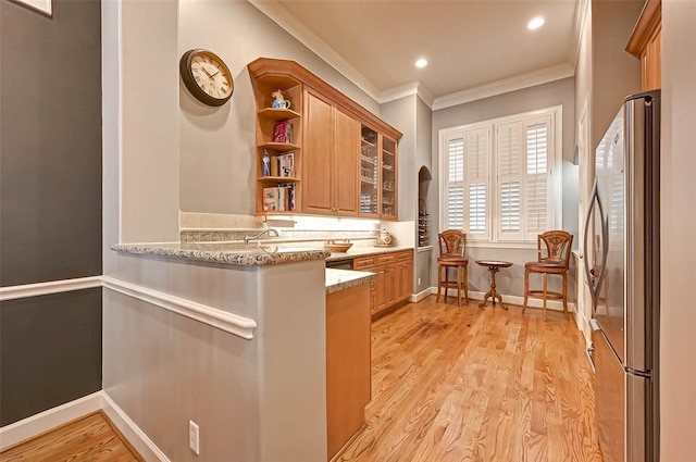109 Dennis St, Houston, TX 77006 - kitchen with freestanding refrigerator, crown molding, brown cabinets, open shelves, and light stone countertops