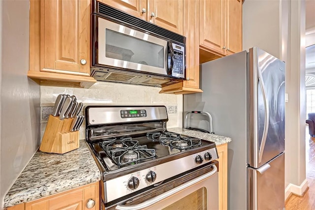 109 Dennis St, Houston, TX 77006 - kitchen featuring stainless steel appliances, light stone countertops, decorative backsplash, and light brown cabinetry