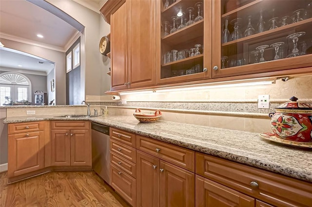 109 Dennis St, Houston, TX 77006 - kitchen with crown molding, dishwasher, light stone counters, light wood finished floors, and arched walkways