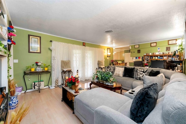 408 Rolling Wood Rd, Baytown, TX 77520 - living room featuring light wood-style floors, a textured ceiling, and crown molding