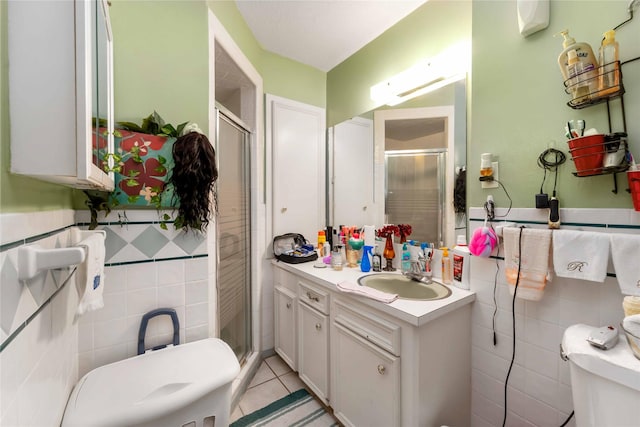 408 Rolling Wood Rd, Baytown, TX 77520 - bathroom featuring tile walls, a shower stall, vanity, tile patterned floors, and wainscoting