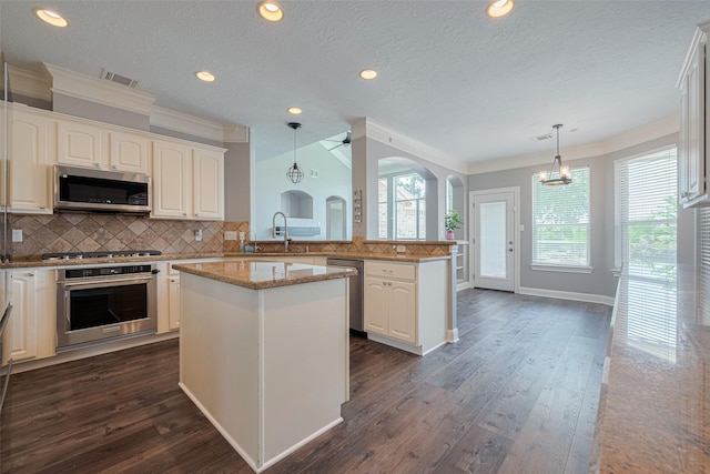 9526 Fern Wood Frst, Houston, TX 77040 - kitchen featuring appliances with stainless steel finishes, ornamental molding, dark wood finished floors, decorative backsplash, and a peninsula