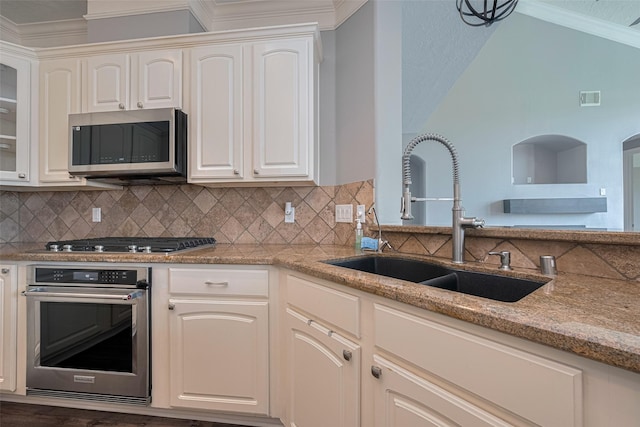 9526 Fern Wood Frst, Houston, TX 77040 - kitchen with stainless steel appliances, light stone counters, backsplash, ornamental molding, and glass insert cabinets