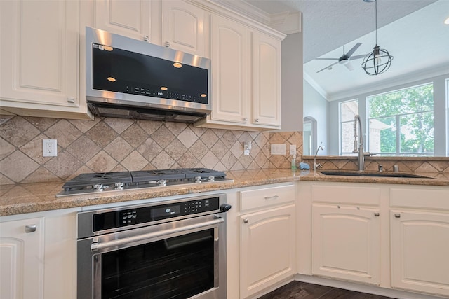 9526 Fern Wood Frst, Houston, TX 77040 - kitchen featuring stainless steel appliances, vaulted ceiling, a ceiling fan, white cabinetry, and tasteful backsplash
